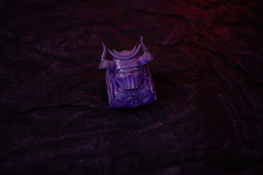 Purple keyabord decorative item (artisan keycap) on a textured dark surface